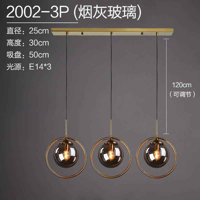Modern 3-light pendant with smoked glass globes and gold rings, adjustable height for contemporary dining or kitchen
