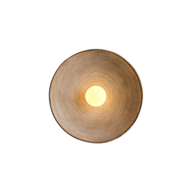 Modern circular wall sconce with concentric ridges and warm glow, ideal for contemporary home decor lighting