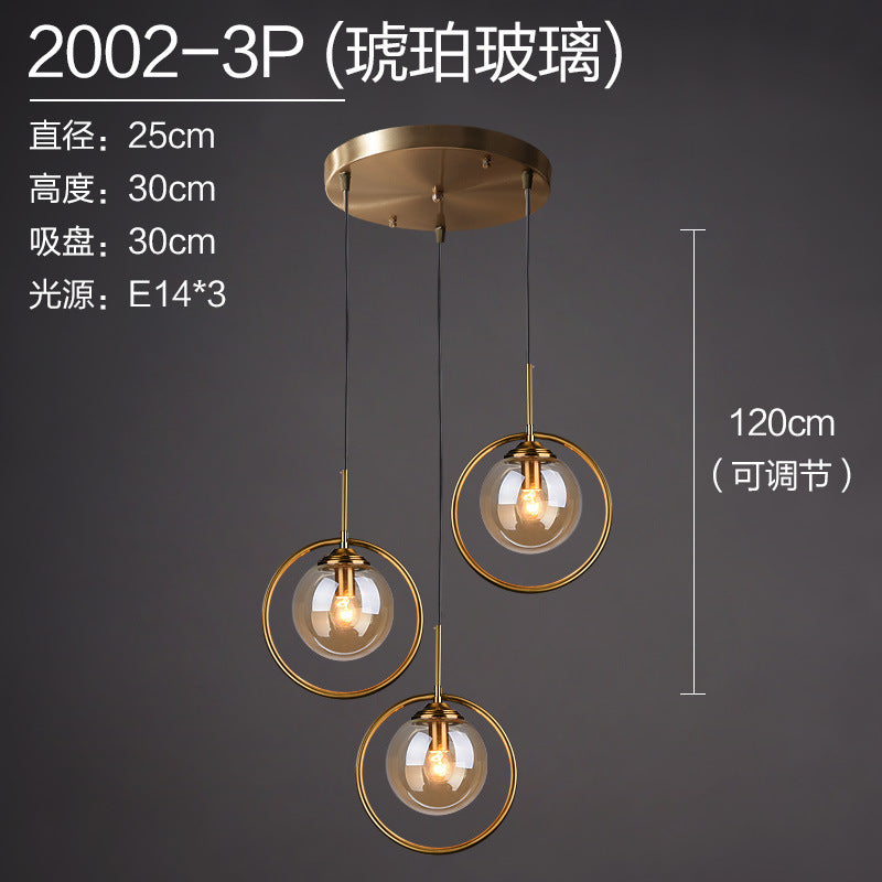Modern pendant light with three amber glass globes, gold rings, adjustable 120cm height, E14 bulbs
